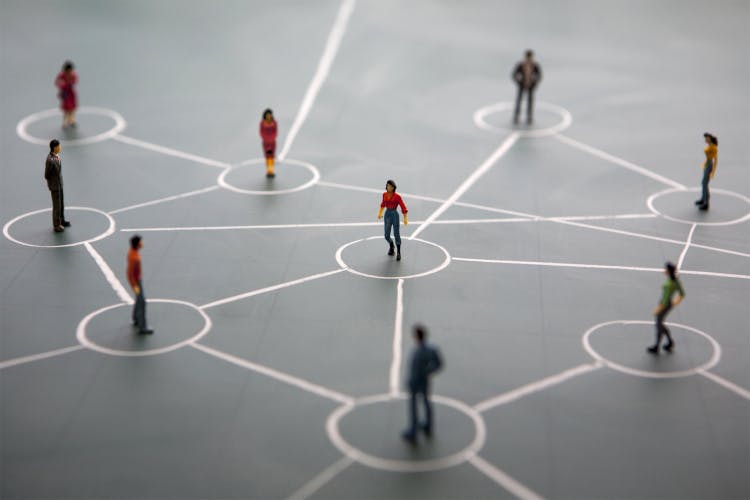 miniature model people standing on drawn chalk network