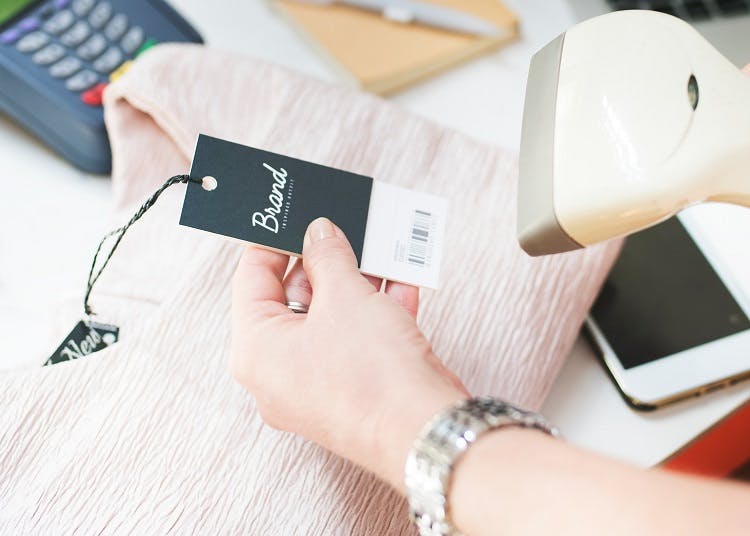 Person scanning clothing label at checkout
