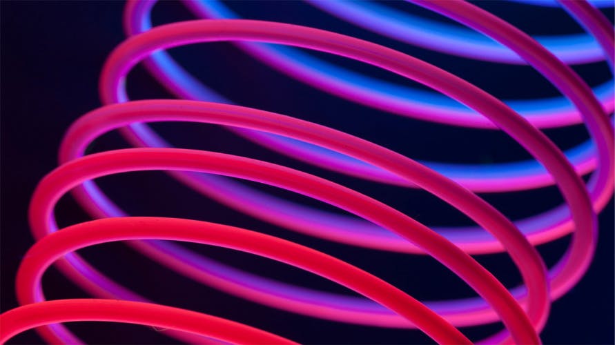 slightly stretched glowing red and blue spring on a blue background