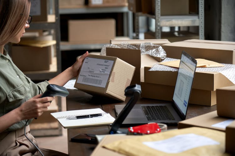 Stock photograph of a worker scanning the barcode on a parcel.