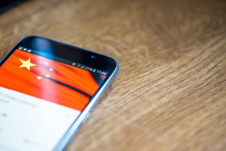 A smartphone with a Chinese flag displaying across the top portion of the screen.